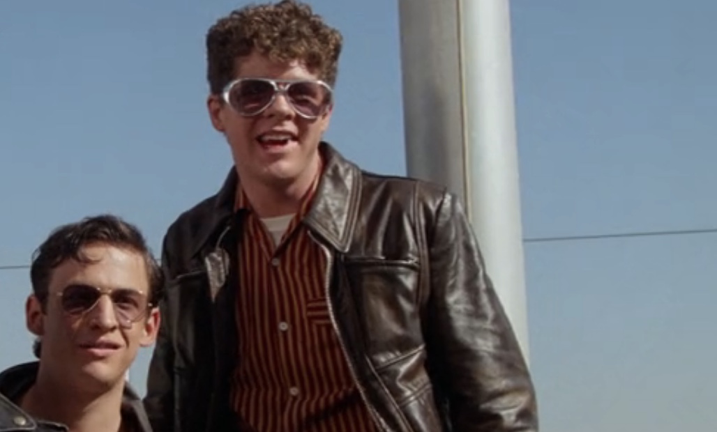 Davey in Grease 2: wearing funny glasses, checkered shirt and a black leather jacket