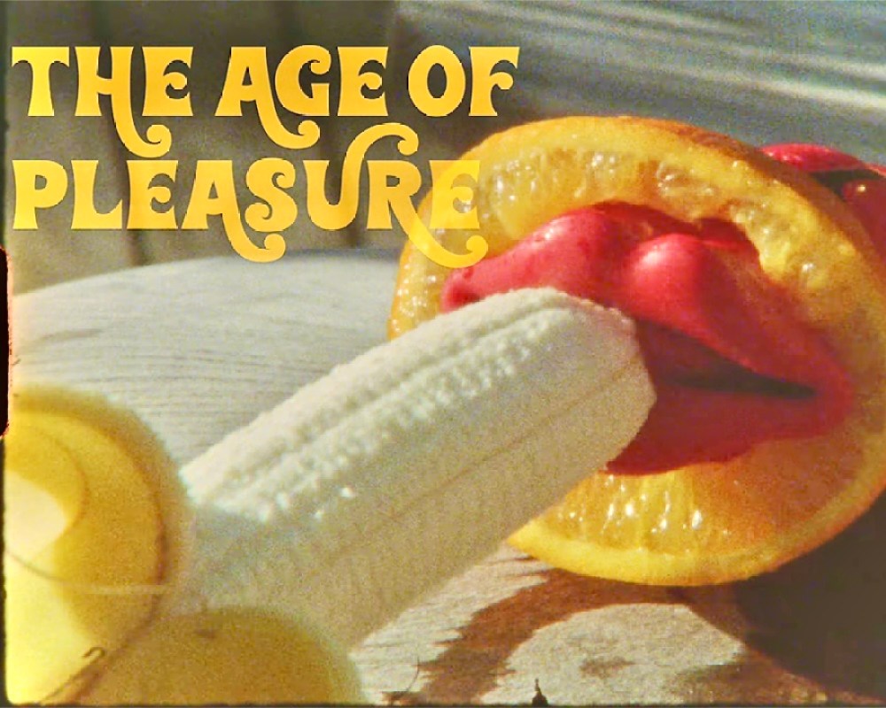 An orange slice with waxy red lips, and a peeled banana going into those lips. Overlayed over the image are the words "the age of pleasure"