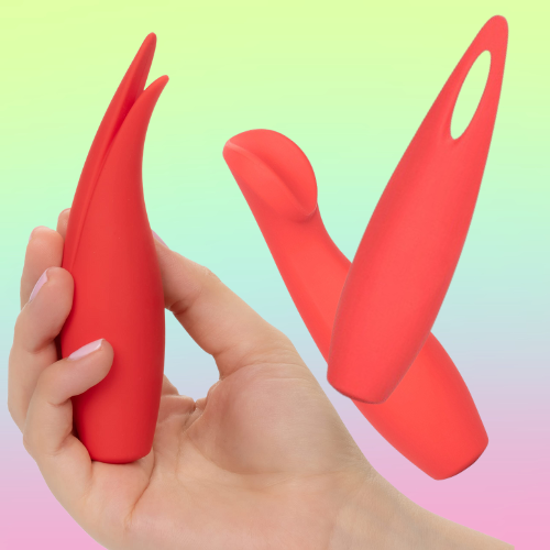 Against a green, blue, and pink ombre background, a white person's hand holds up a red silicone vibrator with two points on the end. Beside the hand, there are two more oblong, red vibrators. One has a pointed end with a hole in it. The other has an end that's shaped like a cup.