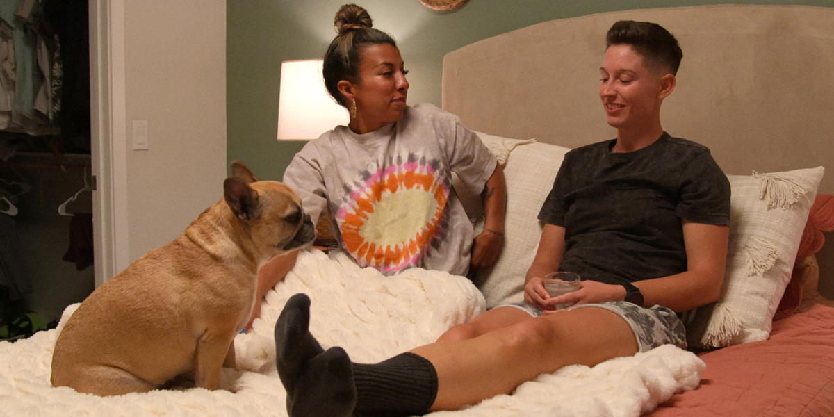 Yoly and Xander in a bed with a fawn French bulldog