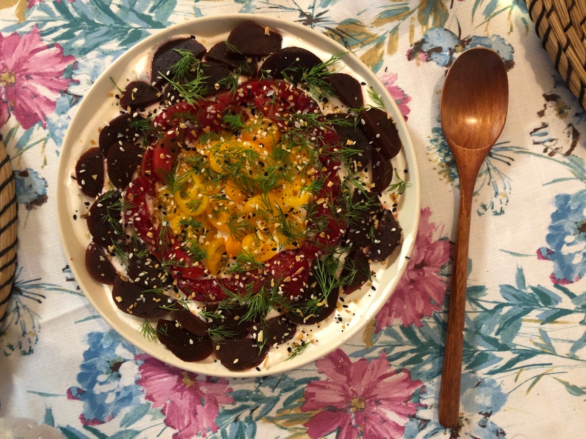 a salad made of sliced beets, sliced plumcots, and tomatoes over Greek yogurt