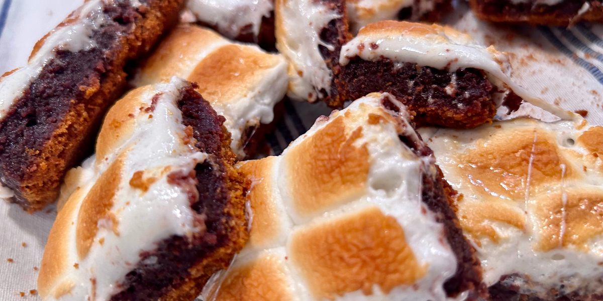 Close up of S'mores Brownies, strewn about messily over a blue and white table cloth