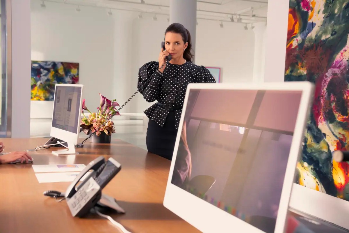 Charlotte chats on the phone at her art gallery