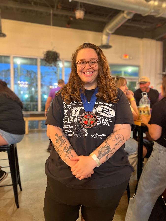 the author Stef Rubino wearing a gold medal at a powerlifting meet