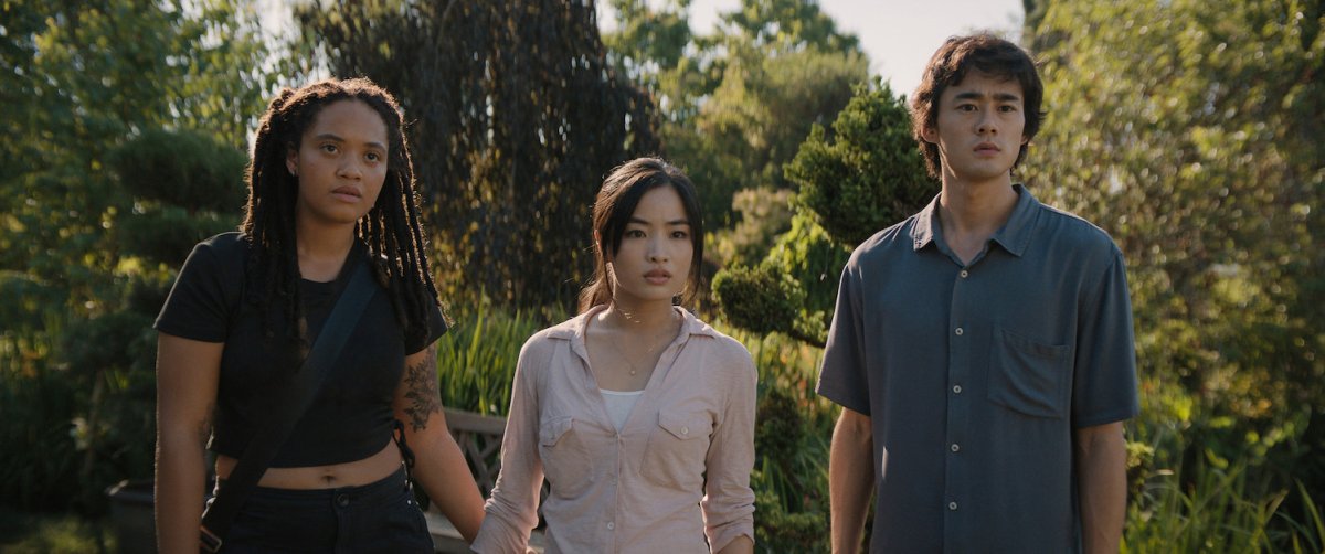 Three young people standing in a garden shocked