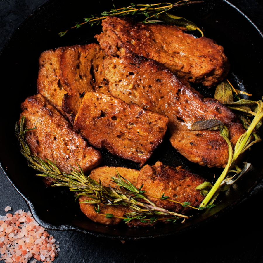 seitan roast in a cast iron pan with herbs