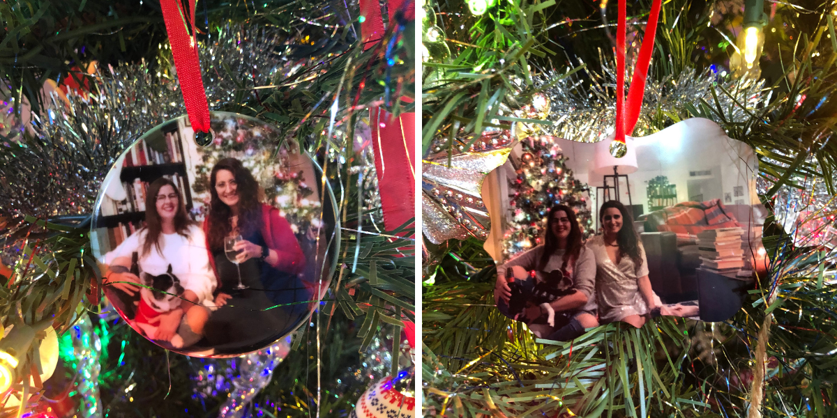 The author Kayla and her fiancee Kristen posing in front of Christmas trees with the french bulldog Lola