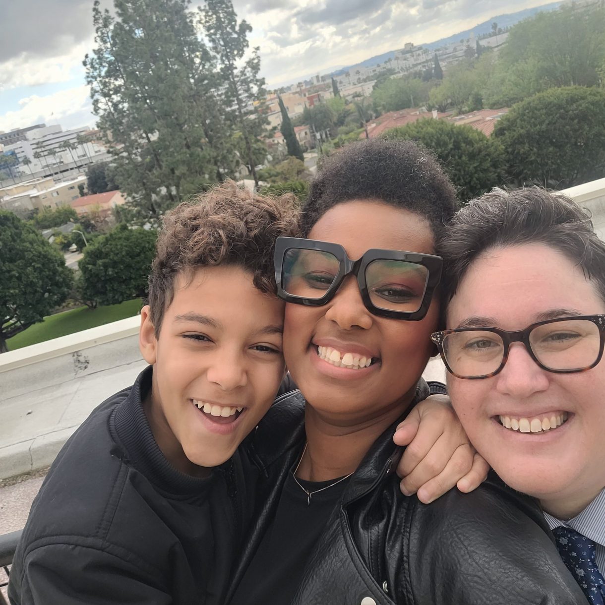 The author (a black woman with short hair) and her wife (a white butch with brown hair) pose on their wedding day with their son.