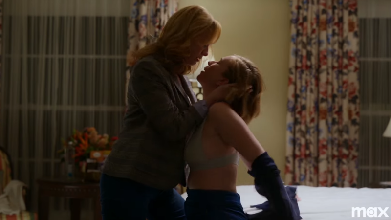 Hacks trailer: Christina Hendricks and Hannah Einbinder kiss on a bed; Christina's character is coming in to kiss Ava, who is taking off her shirt