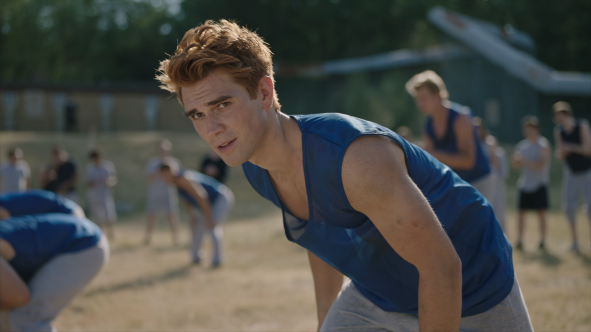 Archie looks up with a smile as he plays football in prison.