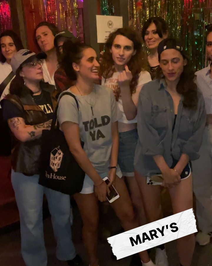 A screenshot of a video of the whole Mary's crew. Drew is gesturing to Tima to stop taking a video and take a selfie instead.