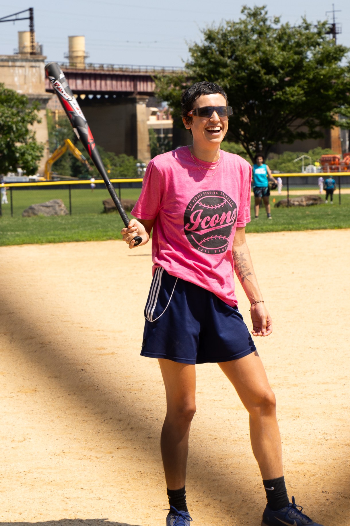 a person in an ICONS shirt swings a bat