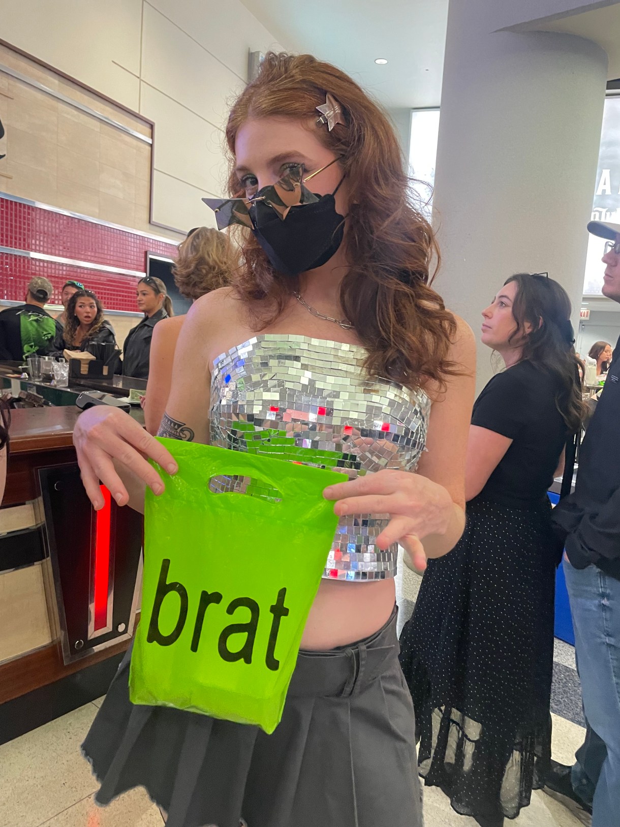 the author's gf wearing a mirror top and holding a brat bag