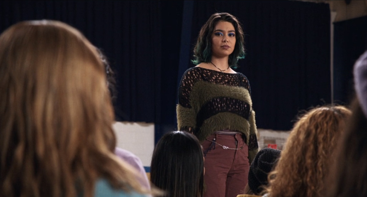 Auli'i Cravalho as Janice looks out at a group of people.