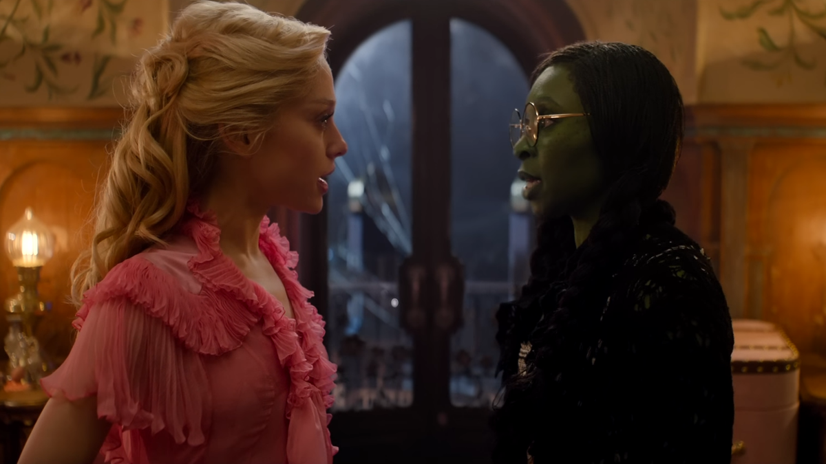 Glinda and Elphaba look at each other in their dorm room.