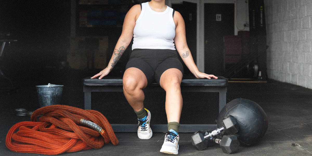 queer person sitting on a weight bench