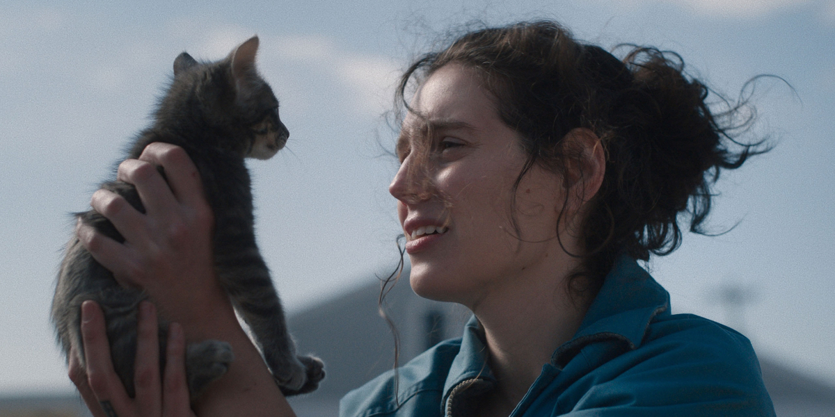 Eva Victor holds up a cat in Sorry, Baby