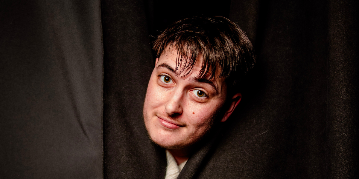 Motti poking his head out of a curtain