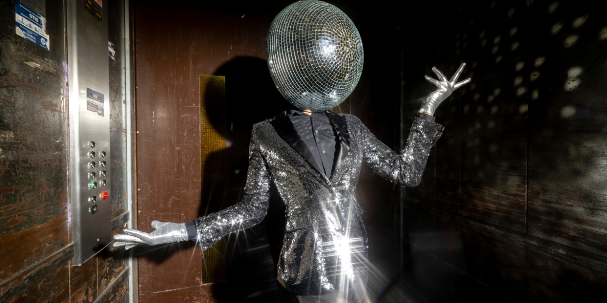 severed floor of the gay club featuring a person with a disco ball head