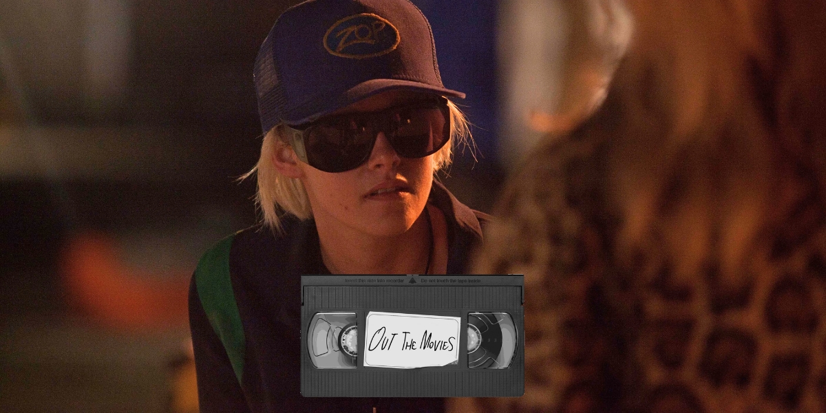 Kristen Stewart as JT LeRoy wearing a hat and dark sunglasses. The Out the Movies logo at the bottom.