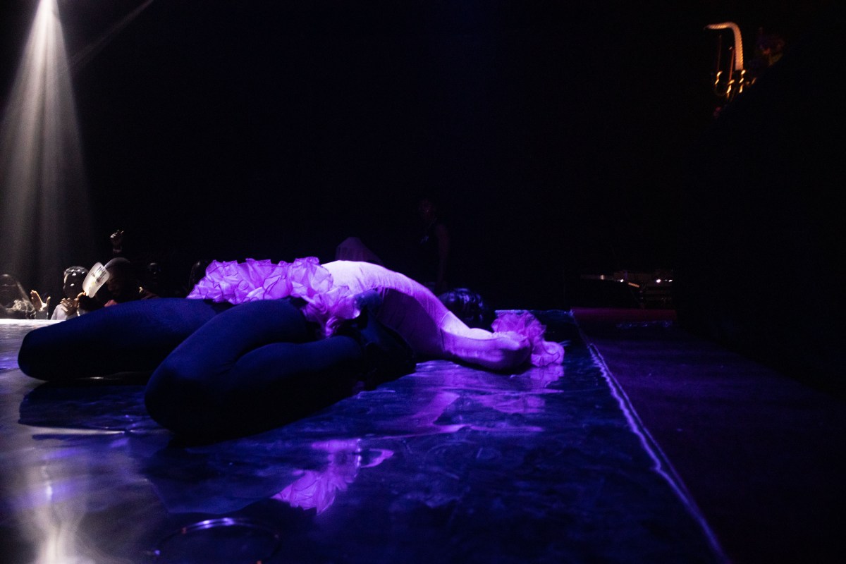Heavenly Bodies a ballroom performer in a death drop, cast in purple light