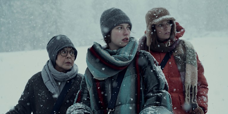 King Princess, Dolly de Leon, and Annie Murphy stand bundled in winter clothes while standing in the snow and looking concerned.