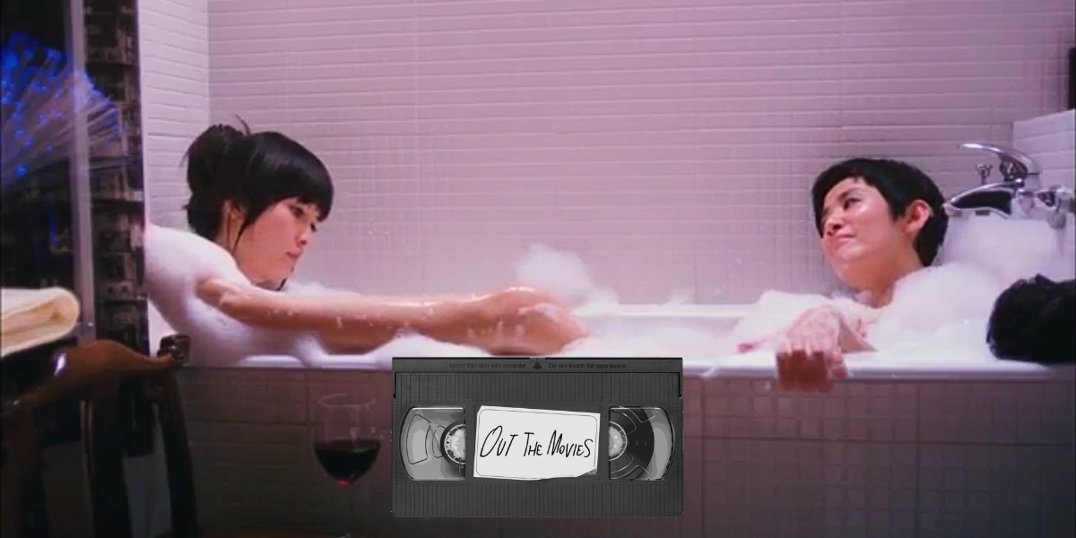 A still of two women in a bathtub together from All About Love with the Out the Movies logo at the bottom