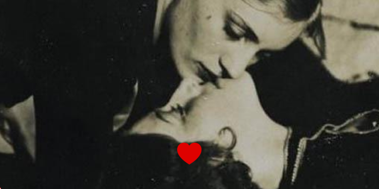 A cropped version of an old photo depicting two women kissing