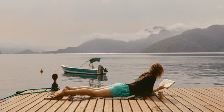 person on lake deck reading