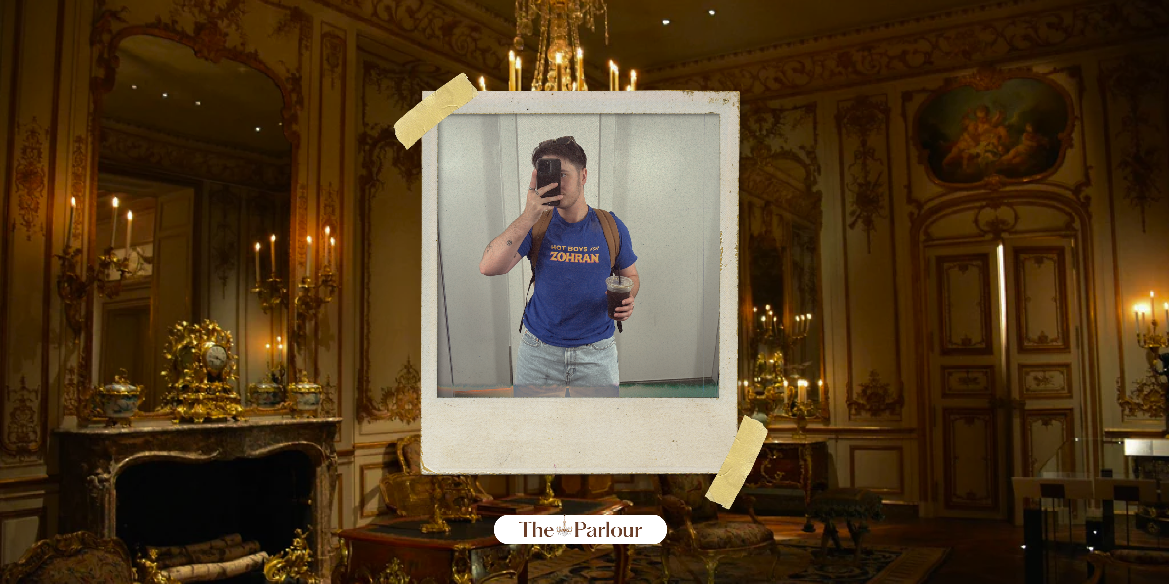 Motti takes a mirror selfie in a hot boys for Zohran shirt with The Parlour image behind him