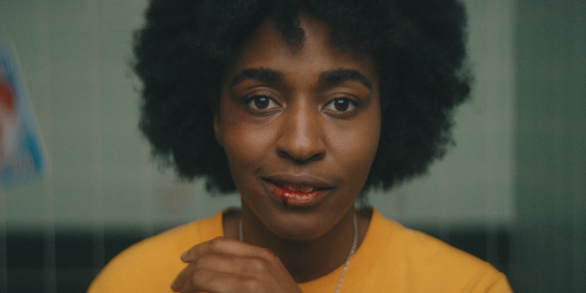 A close up of Ayo Edebiri with a bloody lip in the movie Bottoms now on Blu-Ray from Kino Lorber