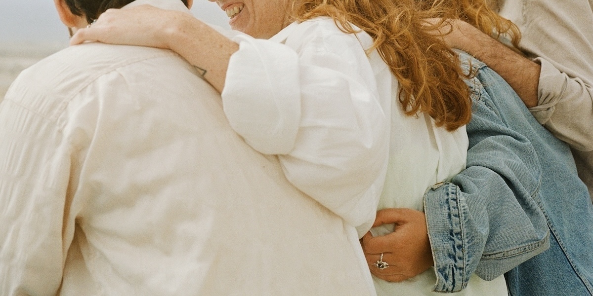 three people side hugging each other