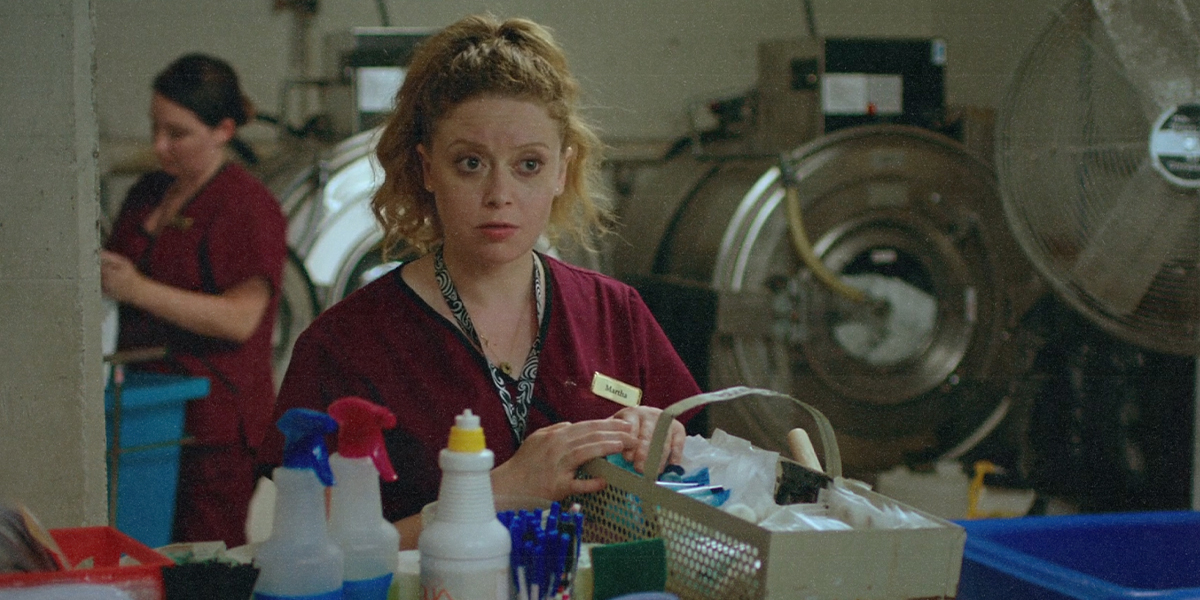Natasha Lyonne in cleaning scrubs with cleaning products