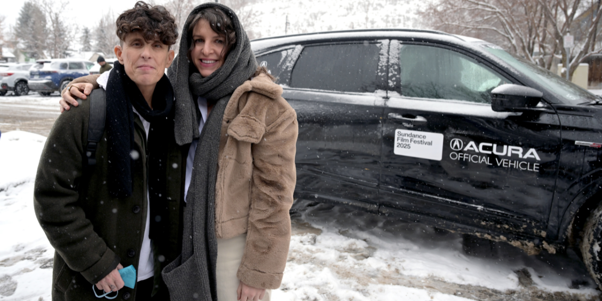 Andrea Gibson and their partner Megan Falley. Andrea is holding a face mask and they are standing in the snow