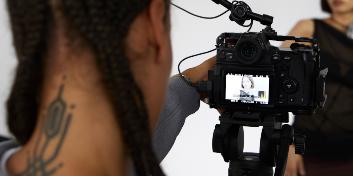 a person with a camera filming someone