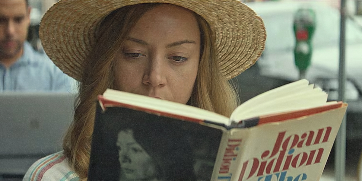 a woman reading a book in a straw hat