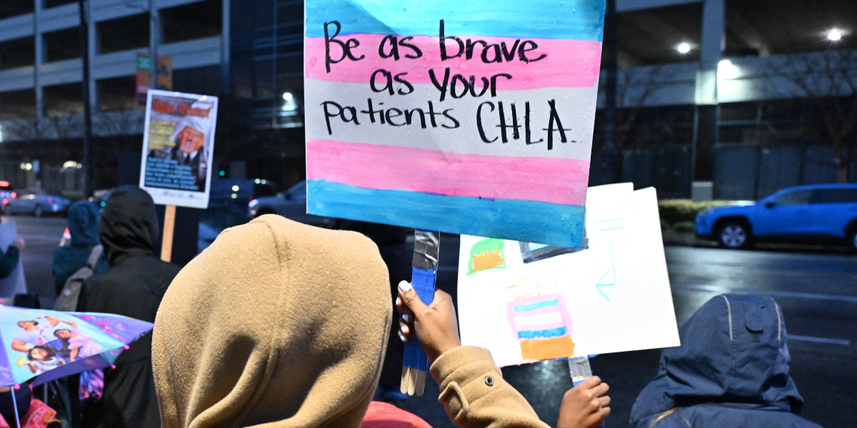 a protest sign targeting the Children's Hospital of LA that reads BE AS BRAVE AS YOUR PATIENTS CHLA