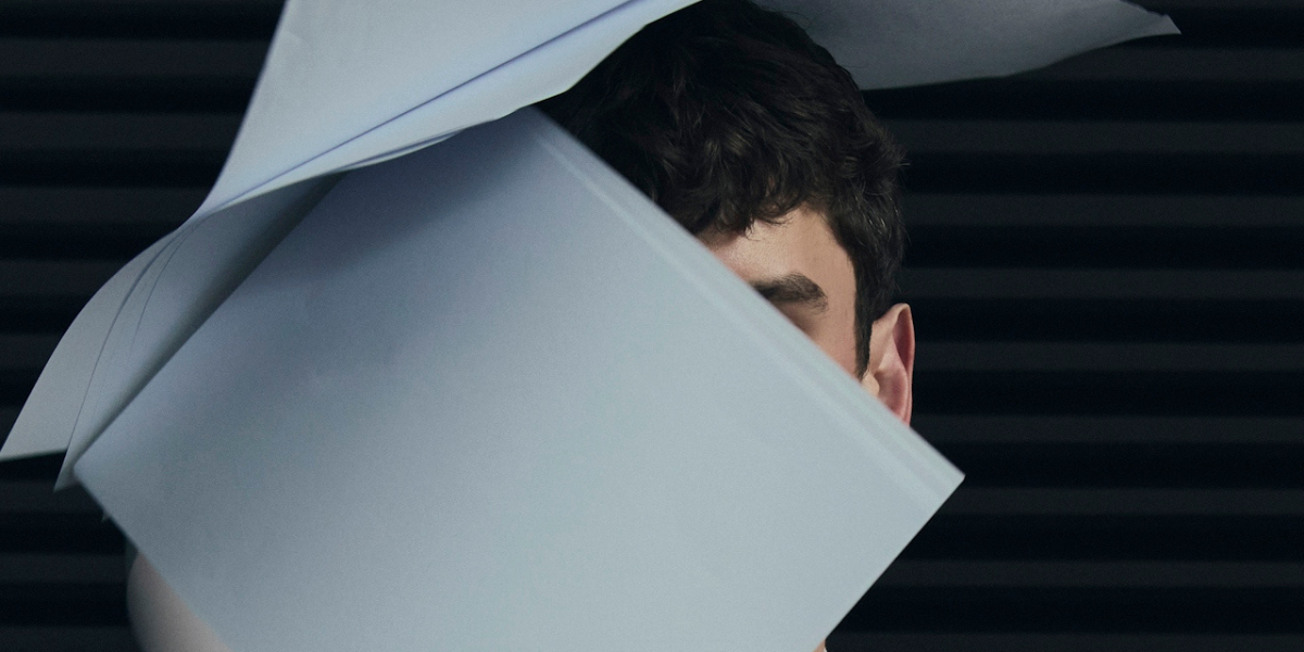 a guy's face covered by flying papers