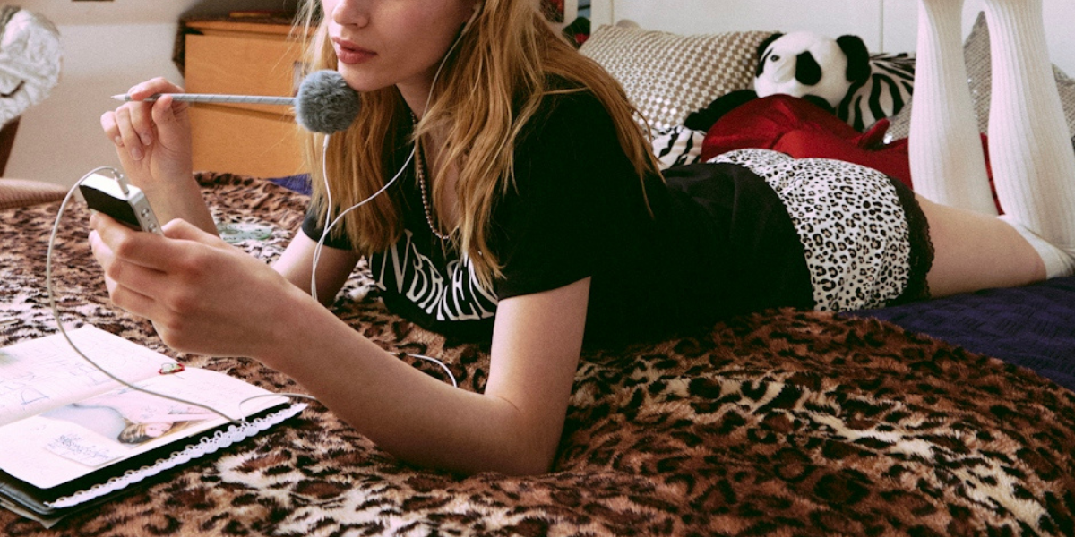 a girl writing in her notebook laying in bed